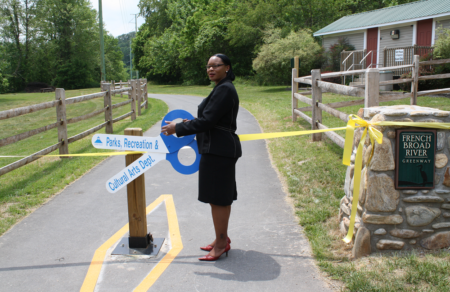 mayor terry bellamy with large scissors at ribbon cutting event