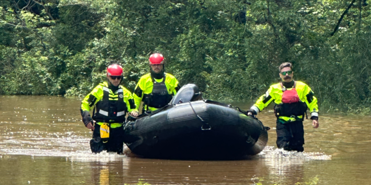 asheville firefighters in flooded water with rescue raft