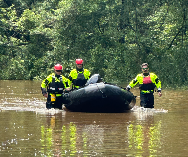 asheville firefighters in flooded water with rescue raft