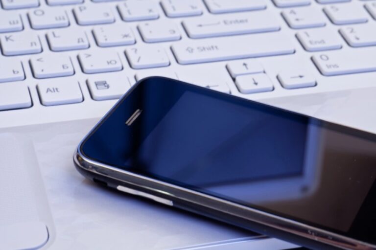 computer keyboard with cell phone laying on top