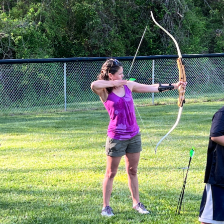 Christy Bass in adult archery class with bow and arrow