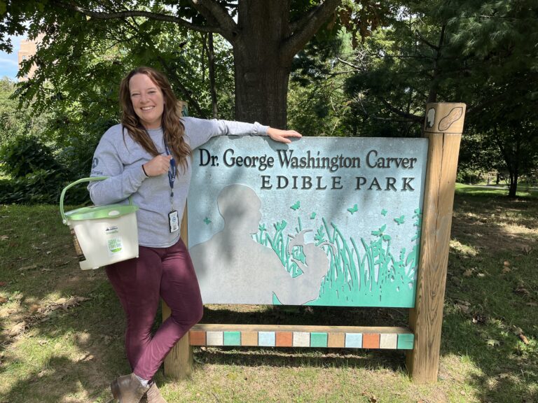 Aurora Wynne stands are George Washington Carver Edible Park sign