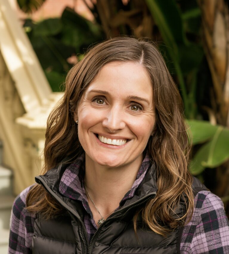 ashley wearing a purple flannel with a black puffy vest