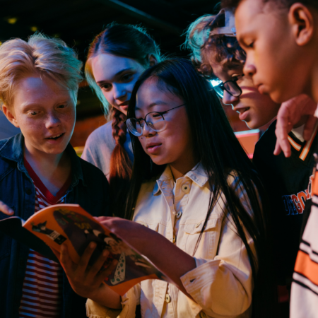 group of teenagers looking at book