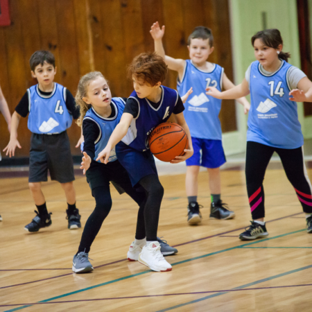 youth basketball team wearing blue shirts playing on court