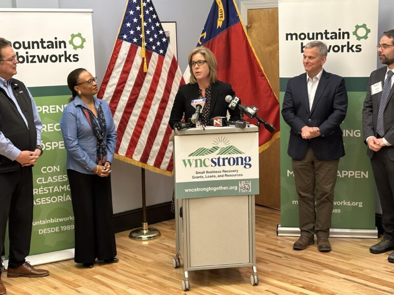 Secreatry Todman on the left of Mayor Manheimer. Governor Stein stands to the right of podium