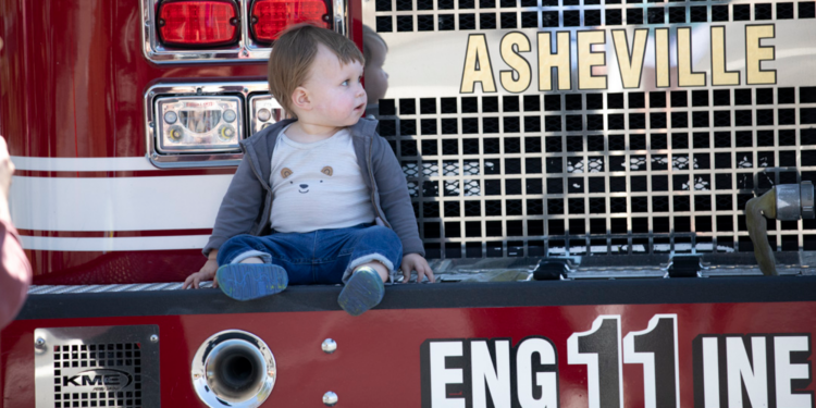 young boy sitting on fire truck